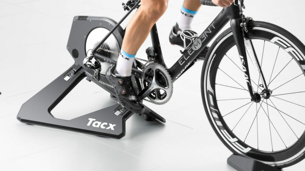 Tacx Neo trainer with bike attached and man with shaved legs pedaling
