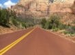 Down hill road in the mountains of Utah with a cyclist descending