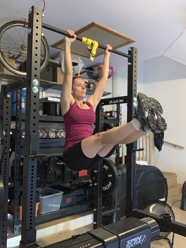 Theia Friestedt doing leg raises hanging from a bar