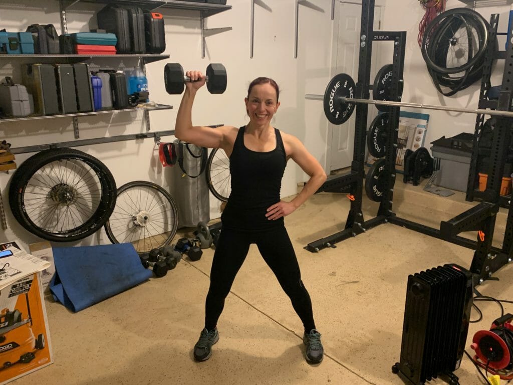 Theia Friestedt strength training holding a dumbell with right arm in push up position