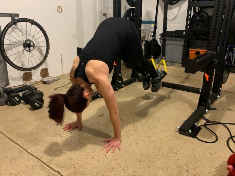 Theia Friestedt doing plank pikes on TRX in the garage